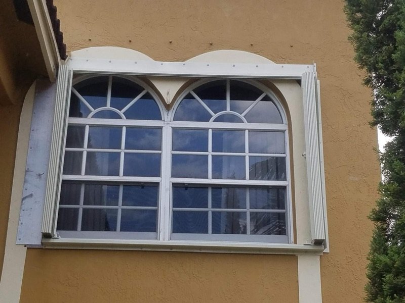Accordion shutter tracks on arched windows in Miami-Dade