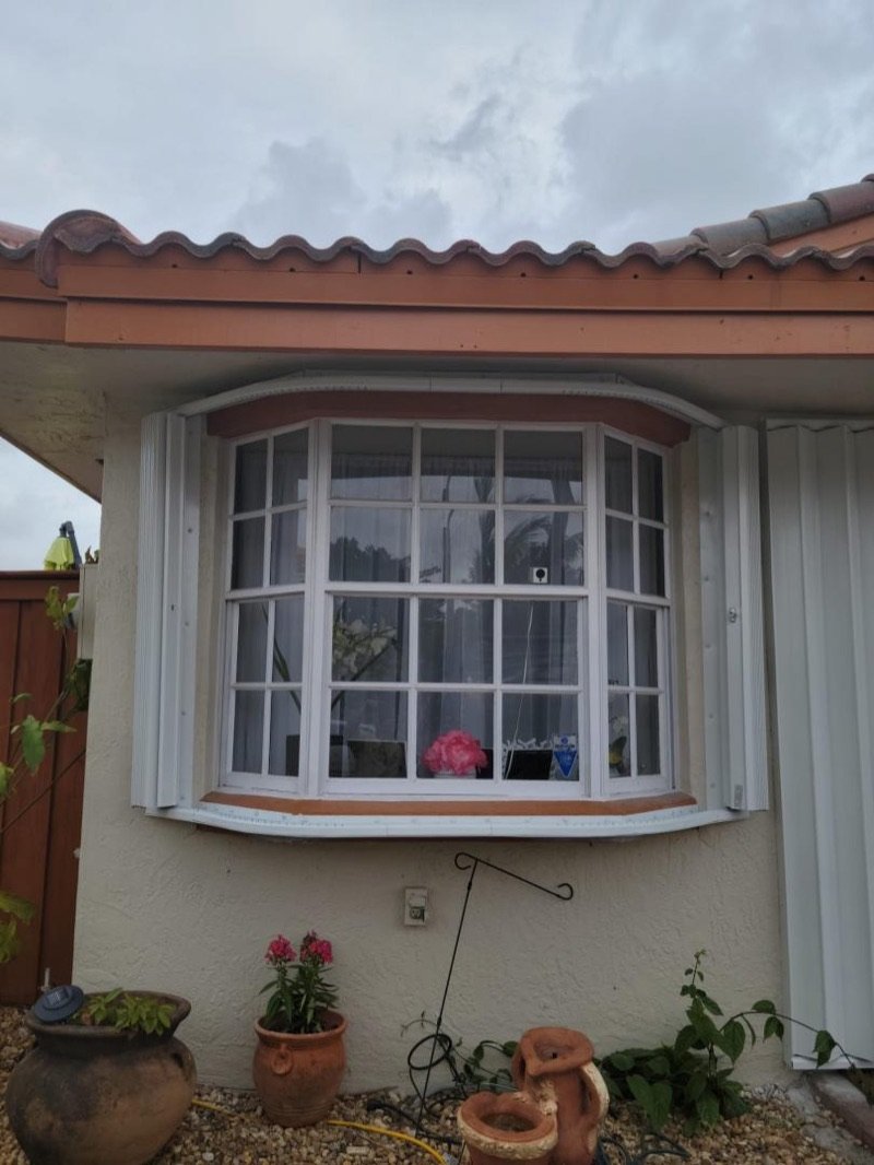 Hurricane shutters installed around a bay window in Miami